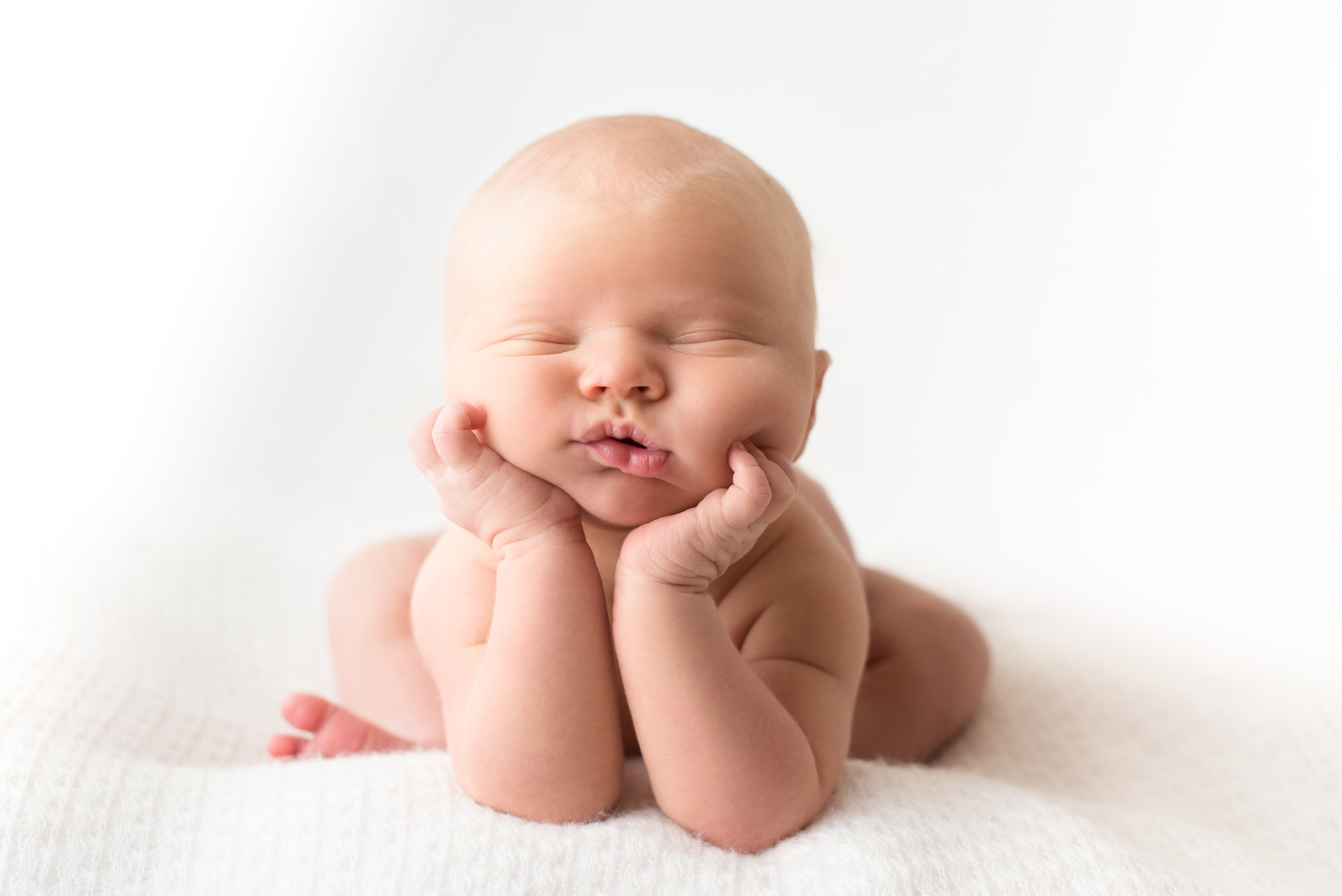 A newborn baby in Susannah Gill's photo studio is in the position called Froggy.