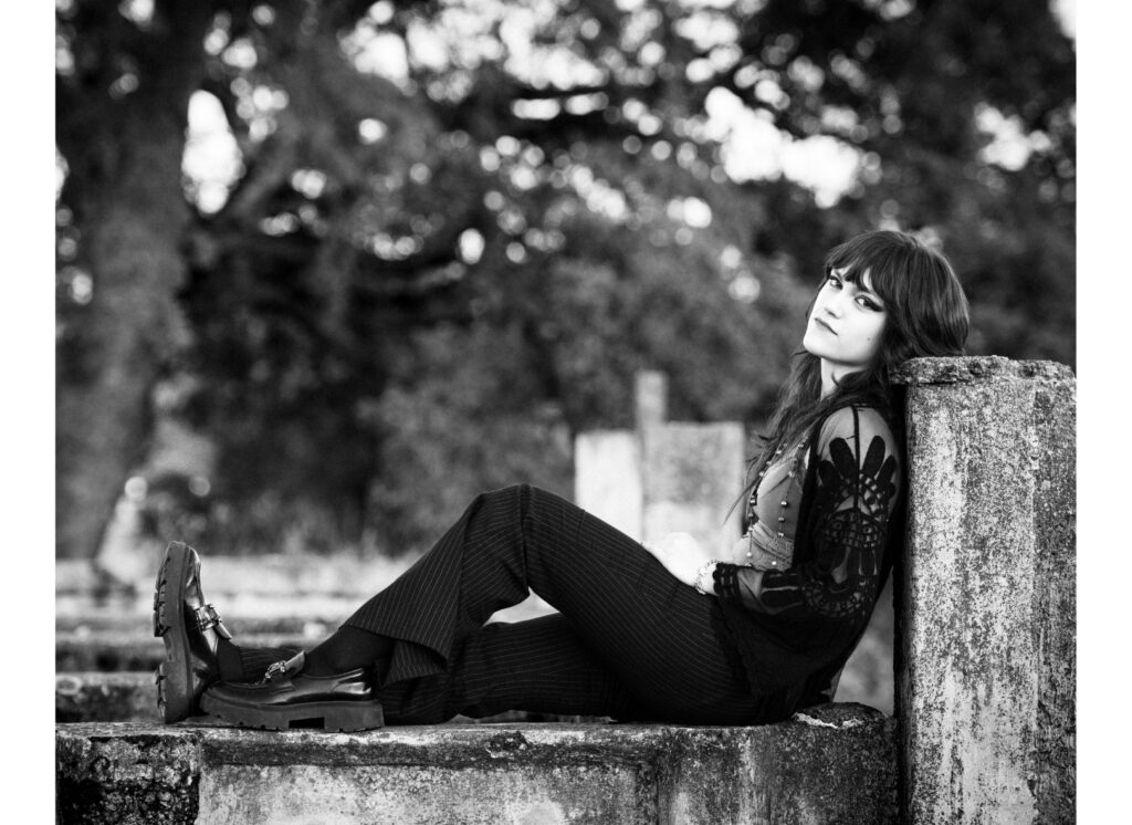 A senior in high school is doing her senior pictures at a ruin to match her edgy style.